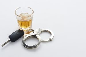 handcuffs keys and a glass of alcohol belonging to someone who is calling a DUI Lawyer fairborn